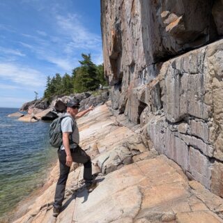 Dit zijn de Agawa Rock Pictografen aan de oever van Lake Superior, in het Lake Superior Provincial Park in Ontario.
De rode figuren zijn geschilderd met ochre (rode oker, een ijzeroxyde pigment gemengd met dierlijk vet of andere bindmiddelen) door de Anishinaabe (Ojibwe) mensen, vermoedelijk 150-400 jaar geleden.
Mishipeshu (de Grote Lynx / Water Panther) — het meest iconische figuur hier, een bovennatuurlijk waterwezen met een gehoornd hoofd en gestekelde rug is nog net te zien.
De schuine, gladde roze granieten rand is best glad, uitkijken tijdens het bekijken dus.